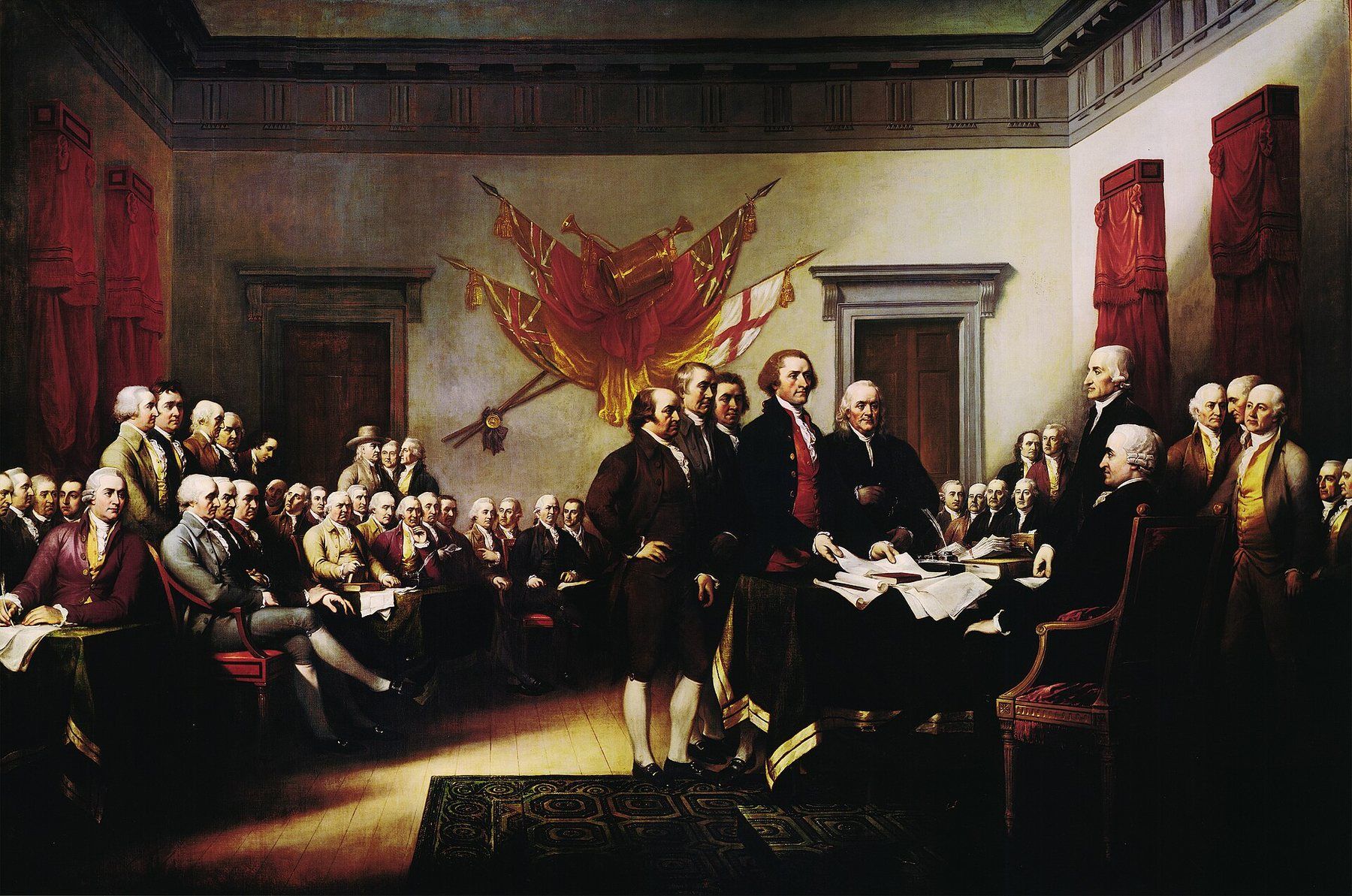 John Trumbull's painting of the Declaration of Independence: the drafting committee presents the document to the Continental Congress in a panelled hall hung with captured flags