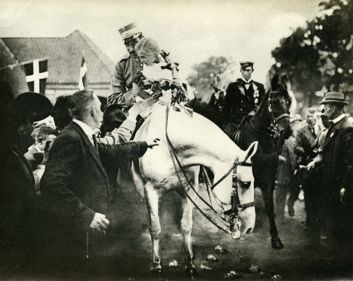 King Christian X on horseback crossing the old border on 10 July 1920, with nine-year-old Johanne Braren lifted onto his horse