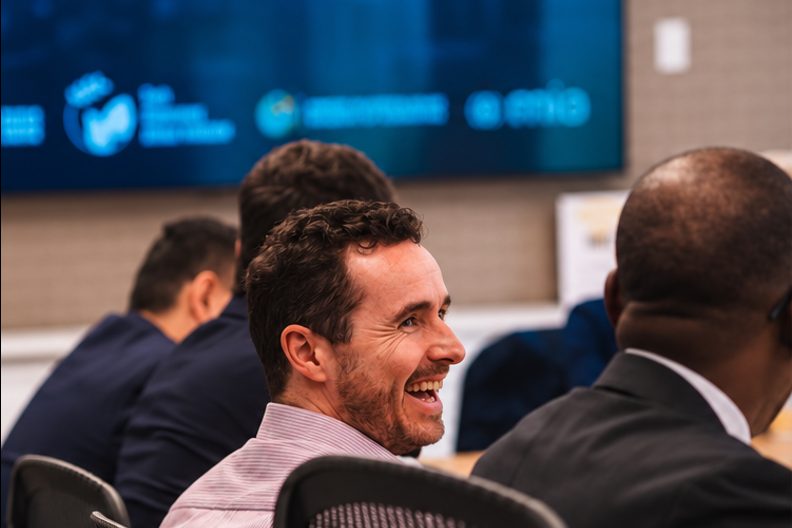 From the Africa Jobs Fund’s post: people around a meeting table, one of them laughing, with a screen of logos behind them